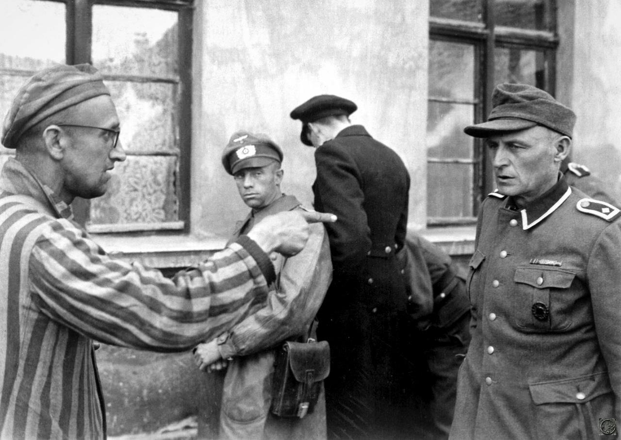 Освобожденный узник указывает на охранника, который жестоко издевался над заключенными в концентрационном лагере Бухенвальд, Германия, 1945